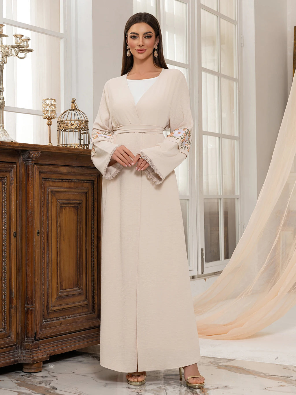 عباية بيج أنيقة تجمع بين البساطة والجمال، مزينة بأكمام مزخرفة بالزهور تضيف لمسة فريدة وعصرية.