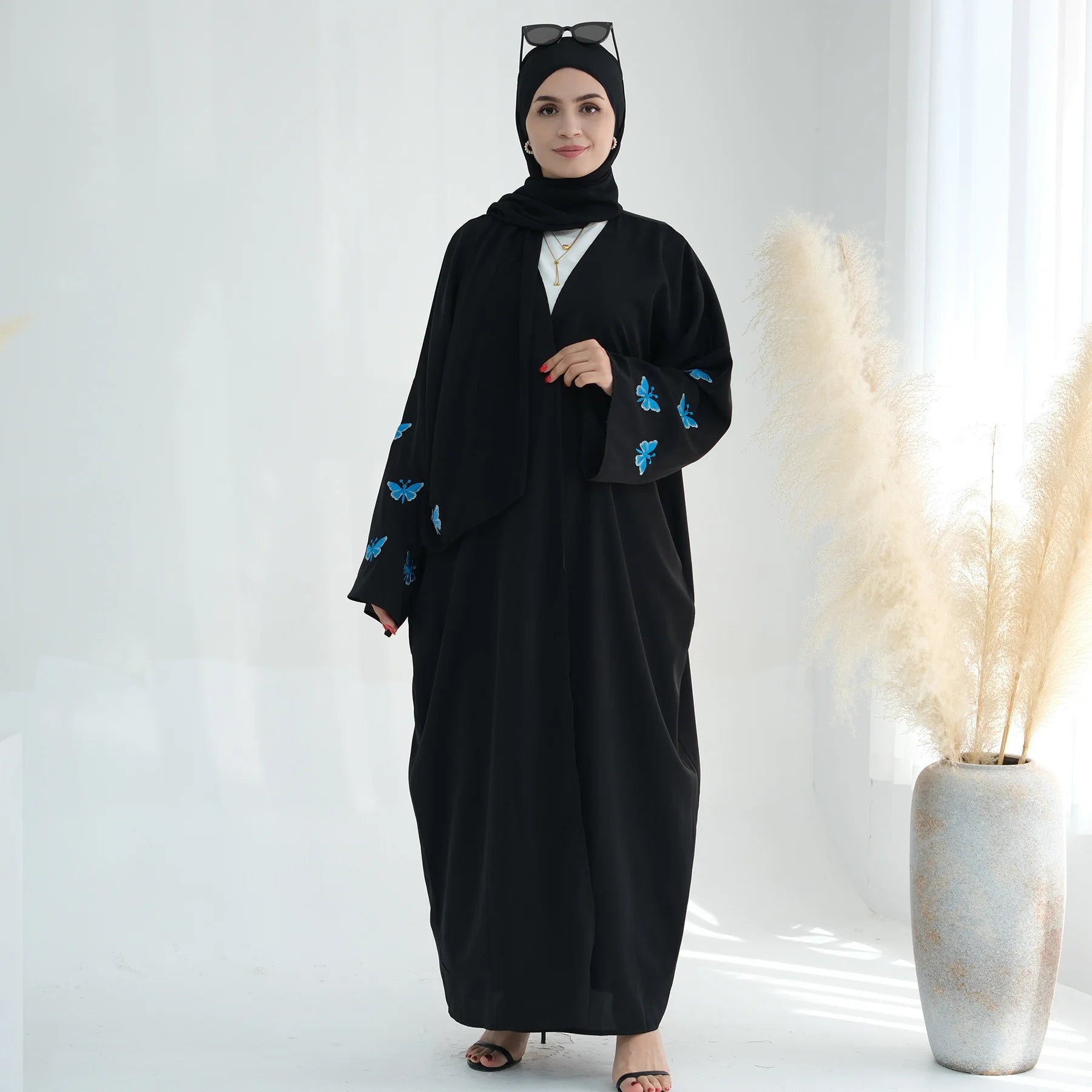 تجسد هذه العباءة المفتوحة تطريز الفراشة الدقيق بتصميم الكيمونو،