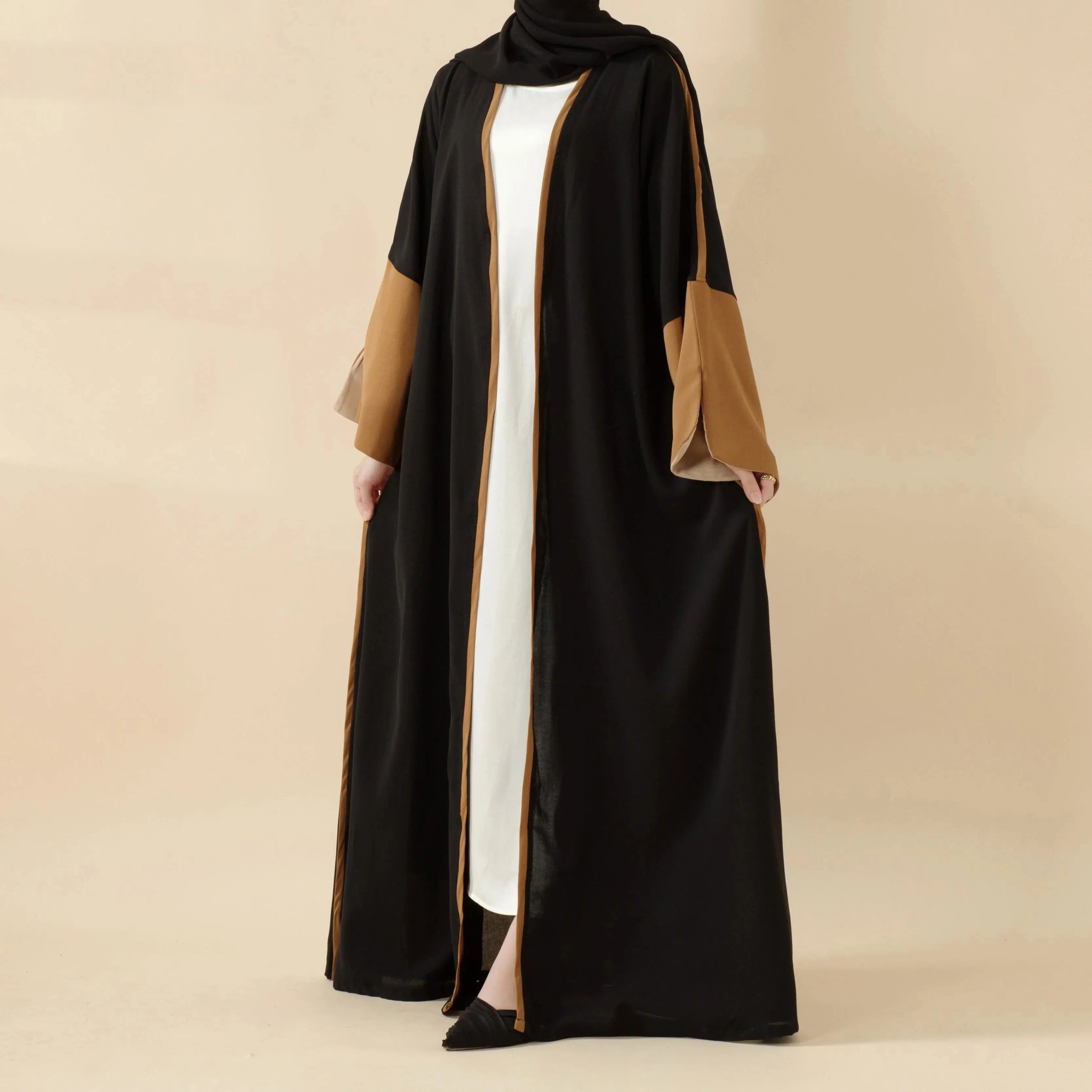 عباءة أنيقة تجمع بين الأسود والبني بتصميم يناسب كل مناسبة، من الارتداء اليومي إلى الاحتفالات الخاصة.