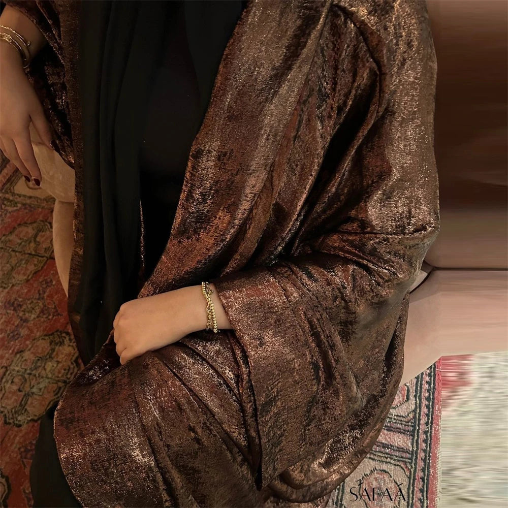 تقدم هذه العباءة الفاخرة بلون بني داكن لامع تصميمًا مستوحى من الأزياء التركية،