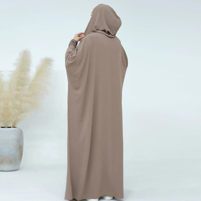 عباءة النسائية المزينة بتعليقات تضفي لمسة من الأناقة المرحة.