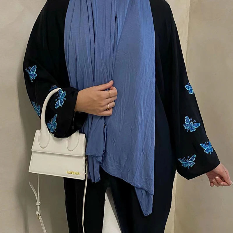 استمتعي بأناقة لا مثيل لها مع عباءة بتطريز فراشة فني يضيف لمسة من الحيوية والجمال إلى إطلالتك.