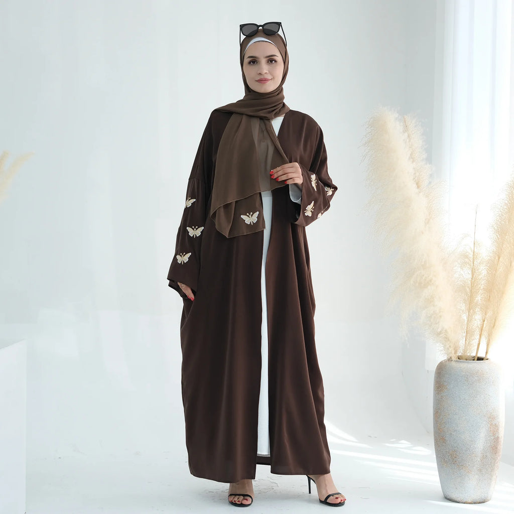 تجسد هذه العباءة المفتوحة تطريز الفراشة الدقيق بتصميم الكيمونو،