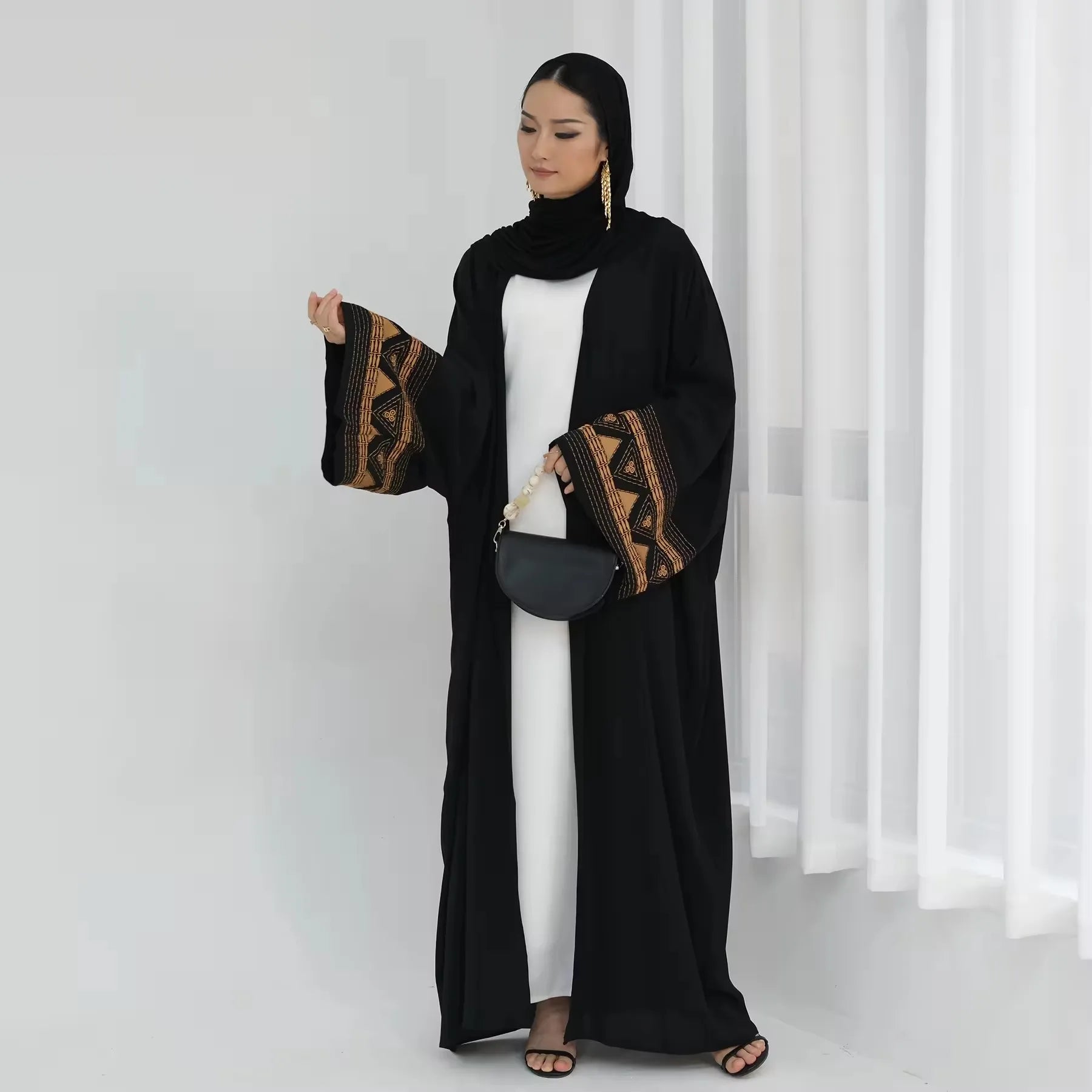 هذه العباءة السوداء المفتوحة بتطريز عرقي أنيق تضيف لمسة مميزة لمظهرك المحتشم.