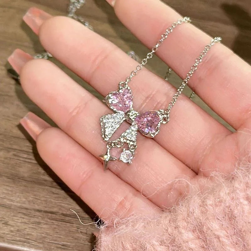 عقد برباط وردي أنيق يضفي لمسة من الرقي على إطلالتك، مزين بقلادة على شكل نجمة تتلألأ بأحجار كريمة مبهرة.