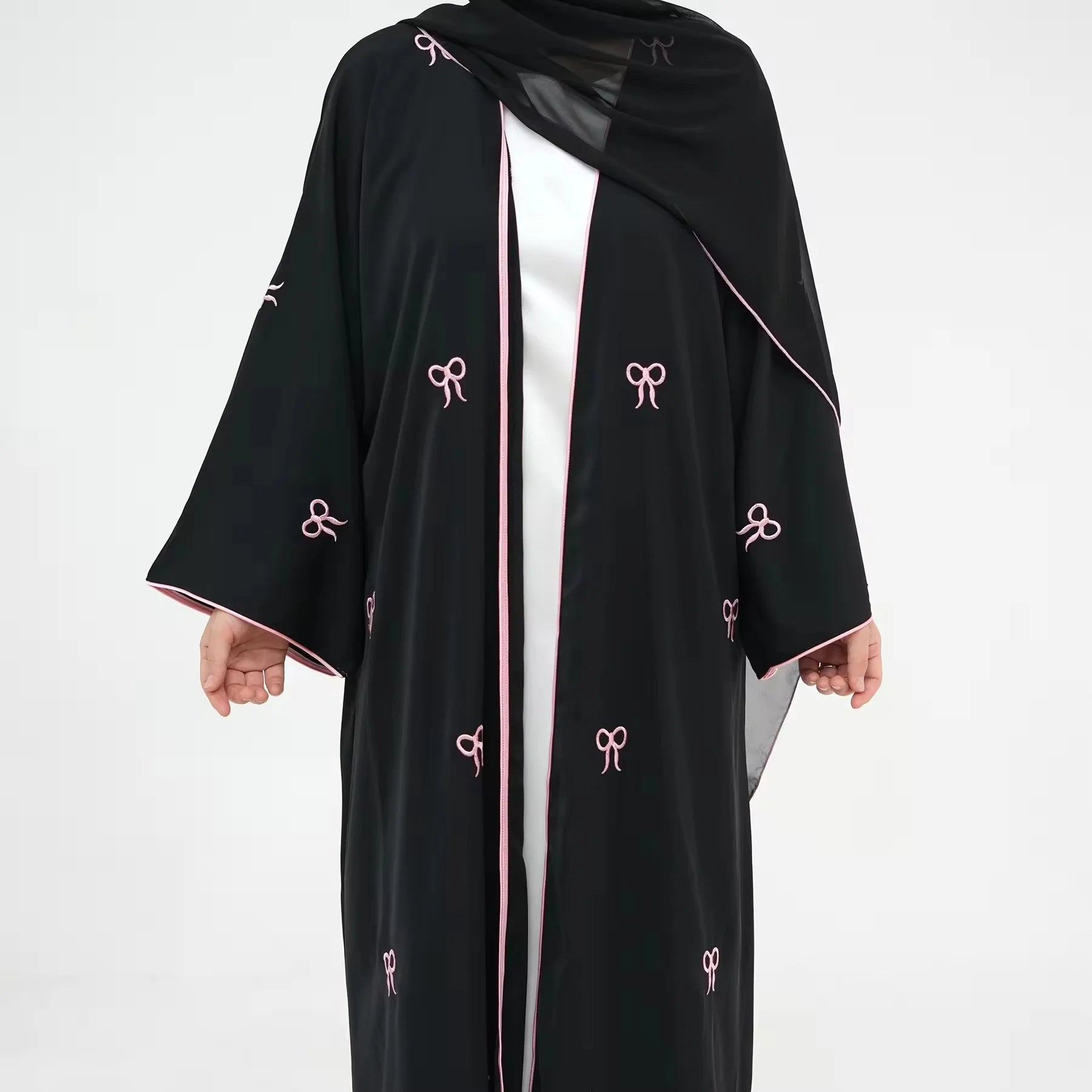 تألقي بأحدث كاردغان محتشم باللون الأسود، مُصمم خصيصًا الباحثات عن الأناقة والراحة في الصيف. تأتي العباءة مطرزة بتطريز قوس الكمون المصنوع من قماش نيدا عالي الجودة،