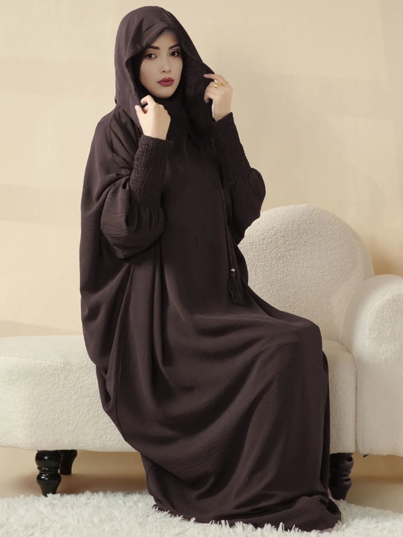 عباءة النسائية المزينة بتعليقات تضفي لمسة من الأناقة المرحة.
