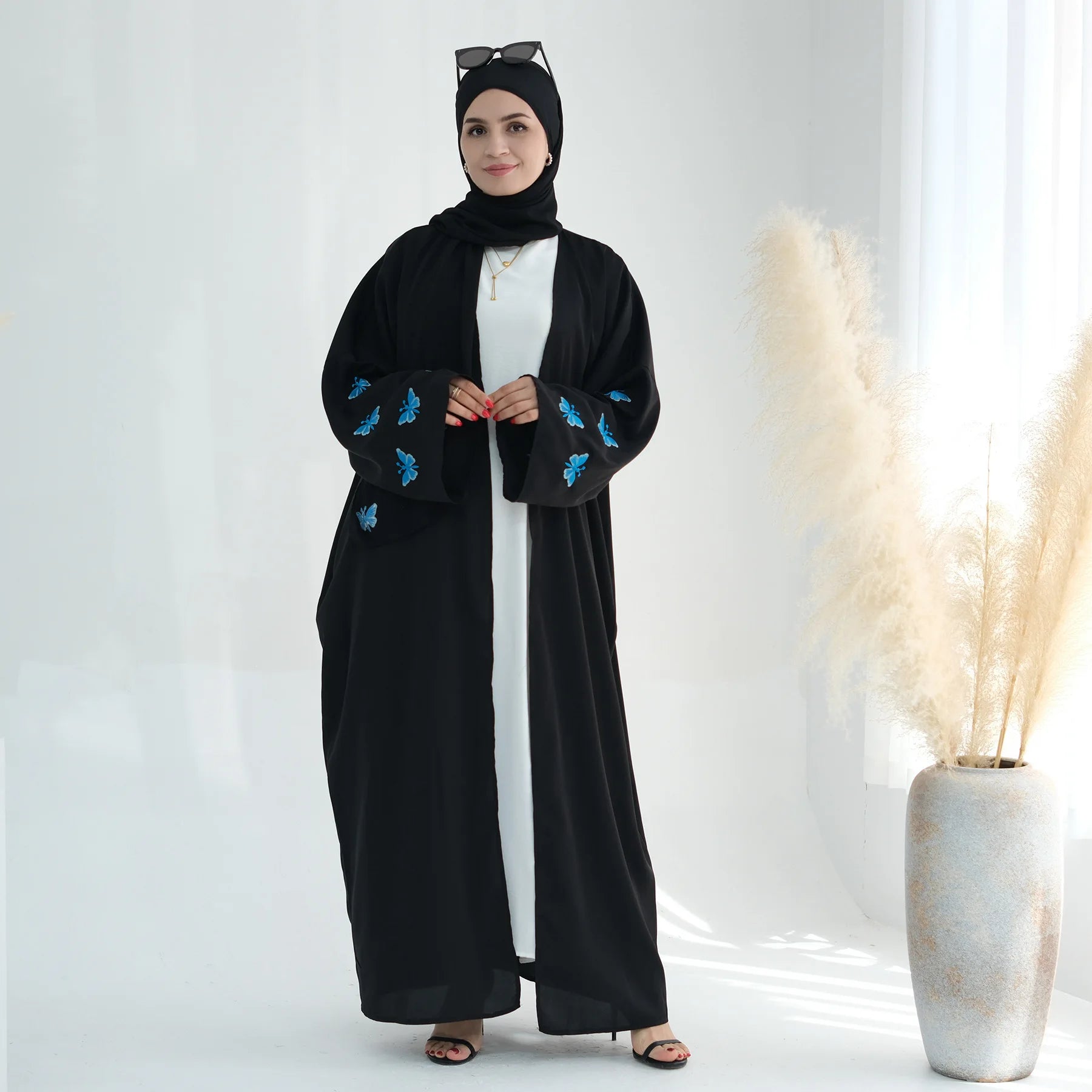 تجسد هذه العباءة المفتوحة تطريز الفراشة الدقيق بتصميم الكيمونو،